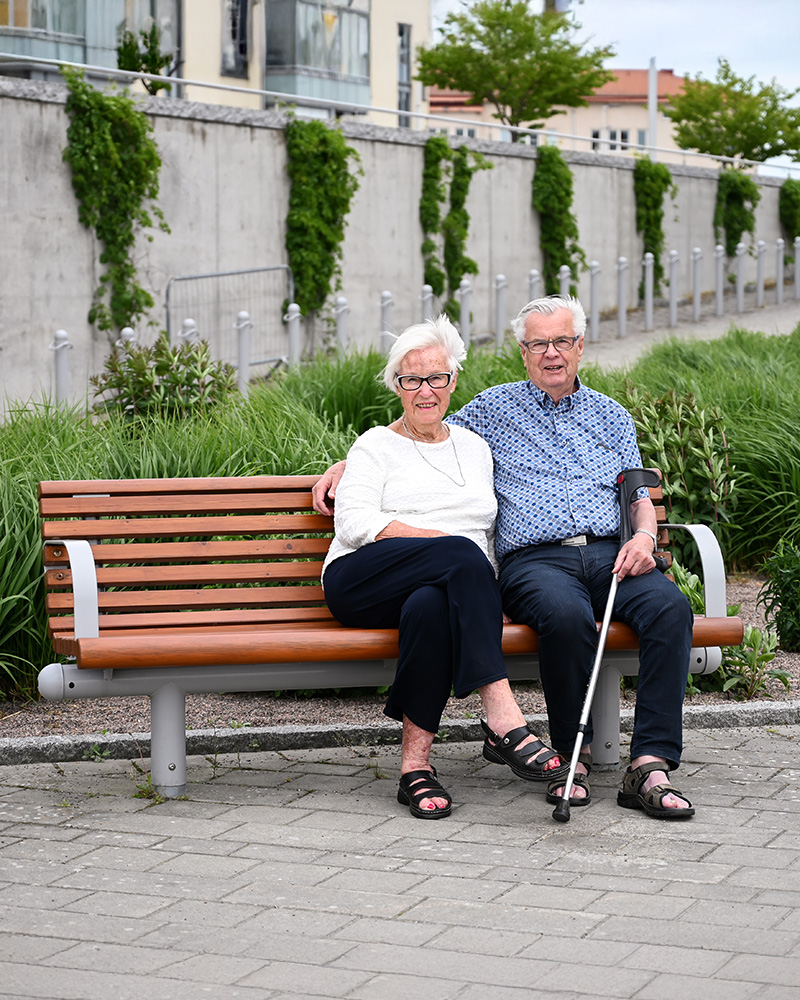 Two seniors sitting on a City-Form park bench.